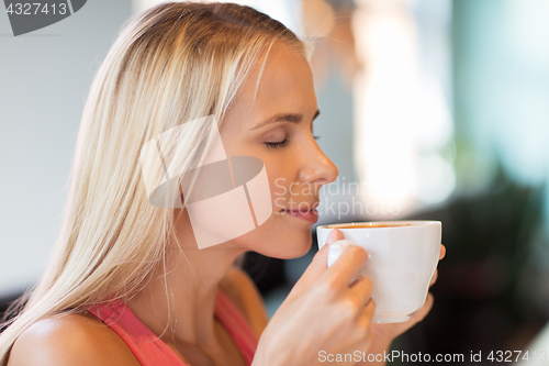 Image of close up of woman drinking coffee at restaurant