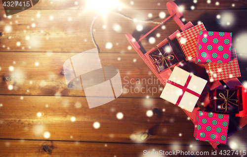 Image of close up of christmas gift boxes on wooden sleigh