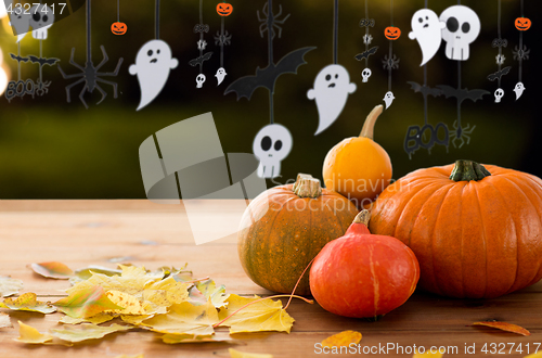 Image of pumpkins with autumn leaves and halloween garland