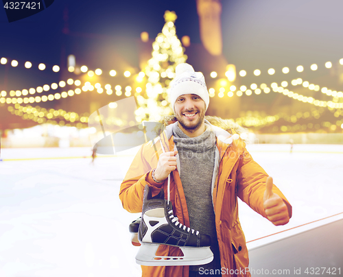 Image of man showing thumbs up on christmas skating rink