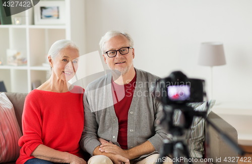 Image of happy senior couple with camera recording video