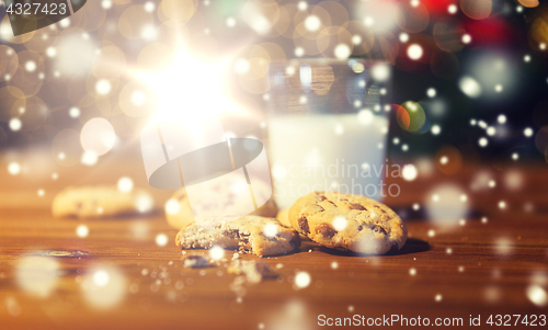 Image of close up of cookies and milk over christmas lights
