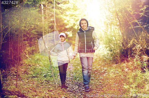 Image of two happy kids walking along forest path