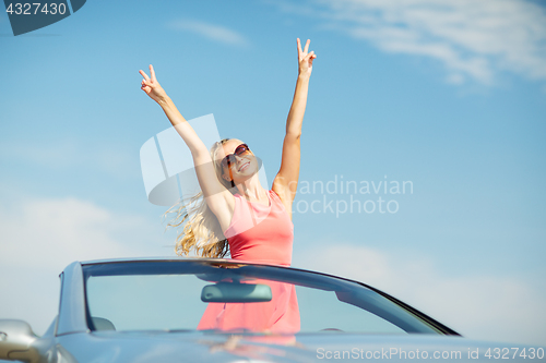 Image of happy young woman in convertible car