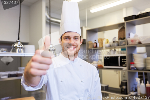 Image of happy chef at restaurant kitchen showing thumbs up