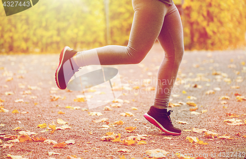 Image of close up of young woman running in autumn park