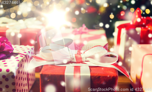 Image of close up of gift boxes over christmas tree lights