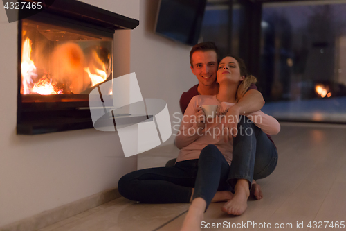 Image of happy couple in front of fireplace