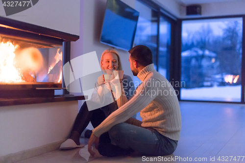 Image of happy couple in front of fireplace