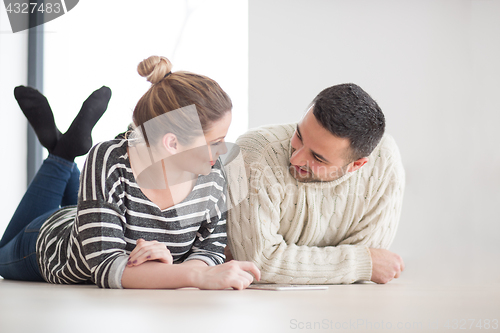 Image of Young Couple using digital tablet on cold winter day