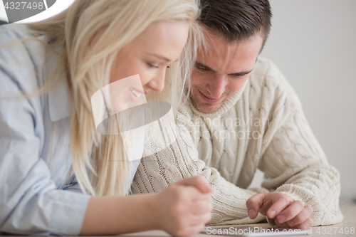 Image of Young Couple using digital tablet on cold winter day