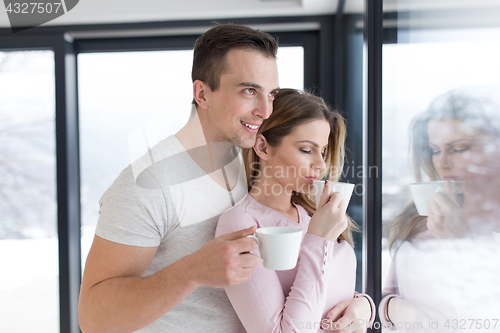 Image of young couple enjoying morning coffee by the window