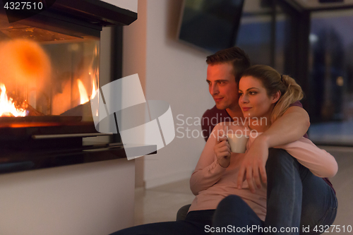 Image of happy couple in front of fireplace