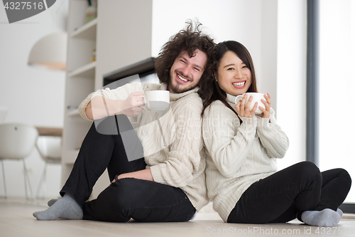 Image of happy multiethnic couple  in front of fireplace