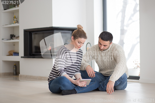 Image of Young Couple using digital tablet on cold winter day