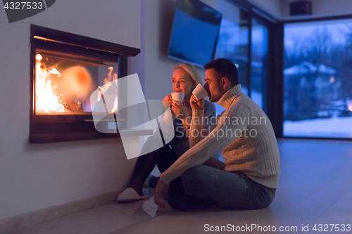 Image of happy couple in front of fireplace