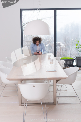 Image of Young casual businessman using smartphone