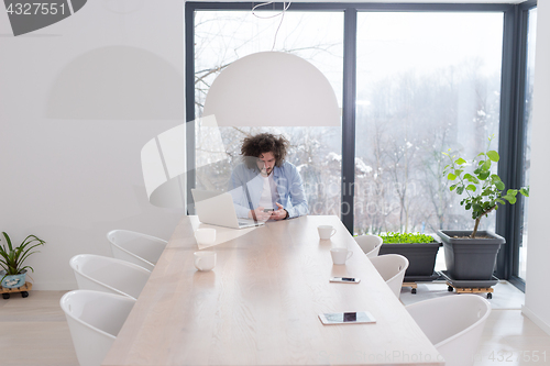 Image of Young casual businessman using smartphone