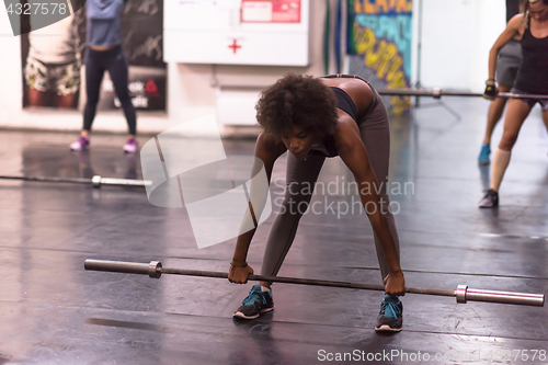 Image of black woman lifting empty bar