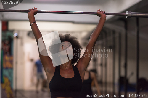 Image of black woman lifting empty bar