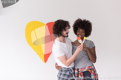 Image of couple with painted heart on wall