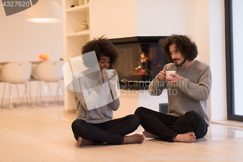 Image of multiethnic couple  in front of fireplace