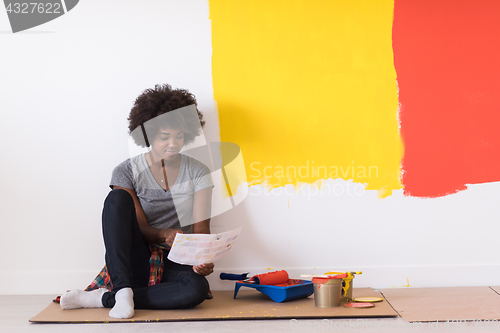 Image of back female painter sitting on floor