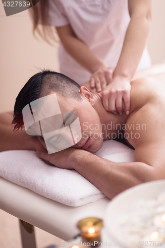 Image of young man having a back massage