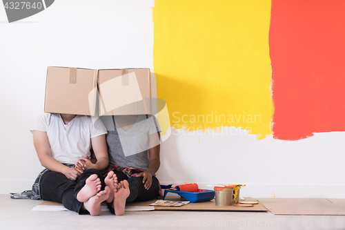 Image of young multiethnic couple playing with cardboard boxes