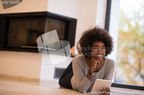 Image of black women using tablet computer on the floor