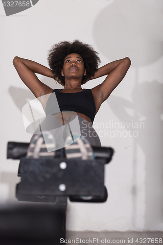 Image of black woman doing sit ups at the gym