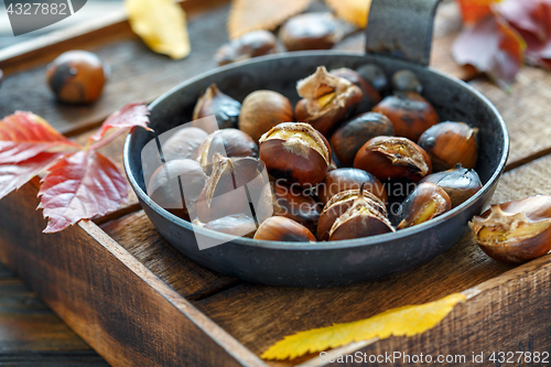 Image of Roasted chestnuts in a cast iron skillet.