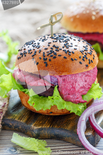 Image of Burger with beef meat, salad and berry sauce.