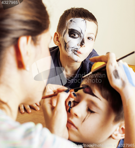 Image of little cute child making facepaint on birthday party, zombie Apo