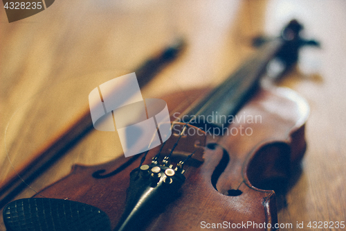 Image of Old violin lying on a wooden surface