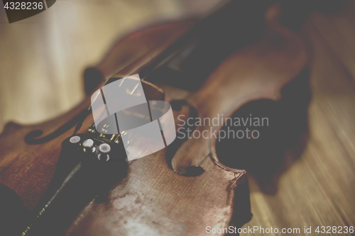 Image of Old violin lying on a wooden surface