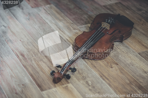 Image of Old violin lying on a wooden surface