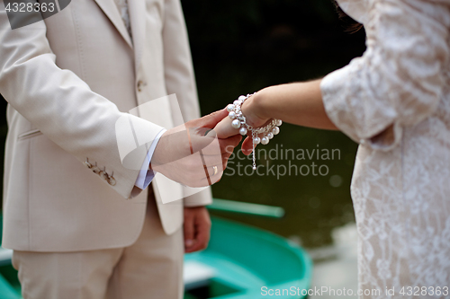 Image of The groom gently holds the bride by the hand