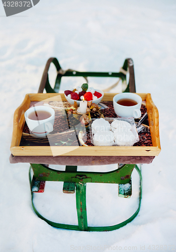 Image of Romantic breakfast in the snow. Winter Vintage Sledge. Coffee, marshmallows, and other sweets