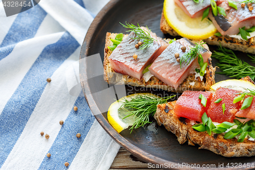 Image of Homemade bread with cheese, herring and green onions.