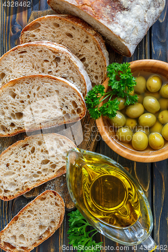 Image of Homemade ciabatta with olive oil and olives.