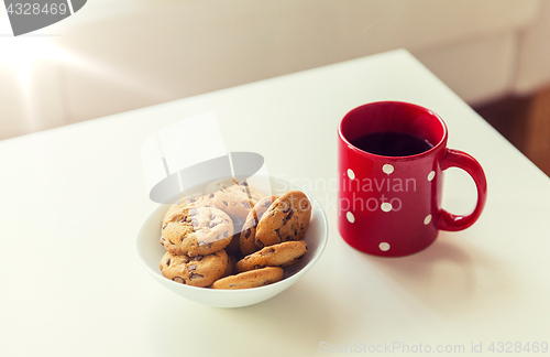 Image of close up of oat cookies and red tea cup on table