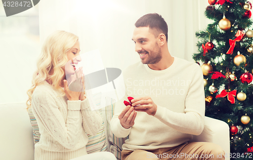 Image of man giving woman engagement ring for christmas