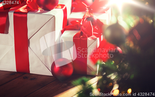 Image of gift boxes and red balls under christmas tree