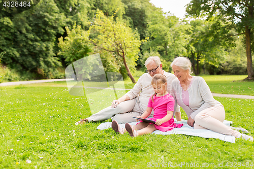 Image of grandparents and granddaughter with tablet pc