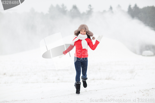 Image of happy woman in winter fur hat outdoors