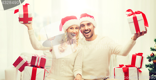 Image of happy couple at home with christmas gift boxes