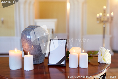 Image of photo frame, cremation urn and candles in church