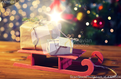 Image of close up of christmas gift boxes on wooden sleigh