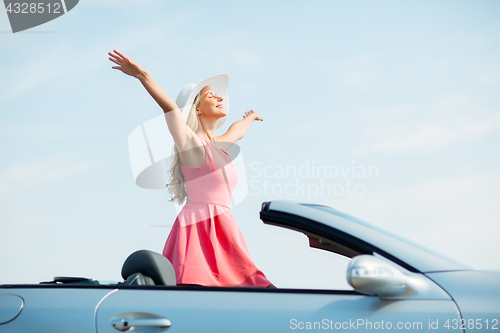 Image of happy young woman in convertible car